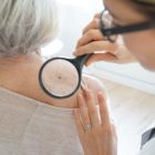 Senior woman getting skin checked by dermatologist